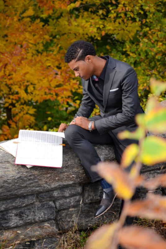 young man looking down reviewing paperwork for his job search and unemployment during the pandemic